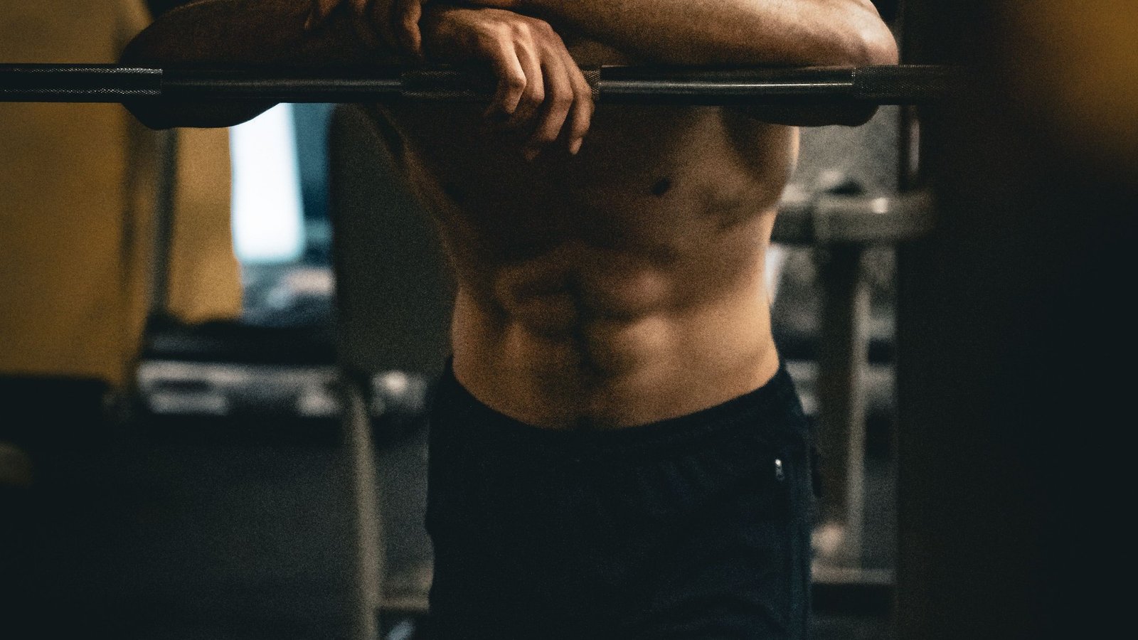 Man performing resistance training in a gym — compound exercises support testosterone through improved body composition and increased androgen receptor density