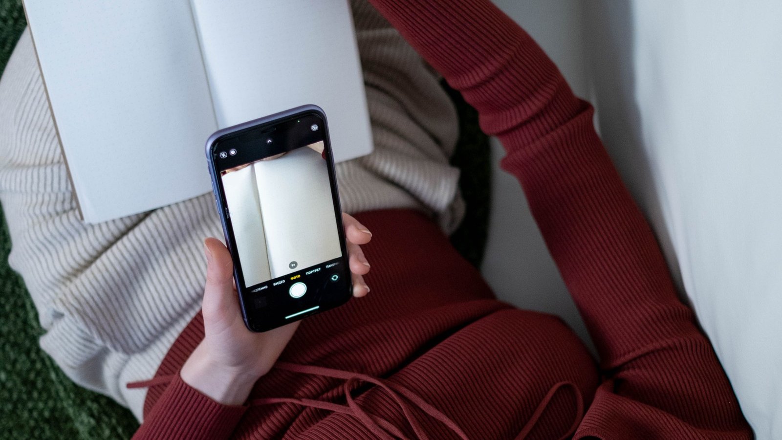 Person looking at phone with a contemplative expression — social media's mental health effects are dose-dependent.