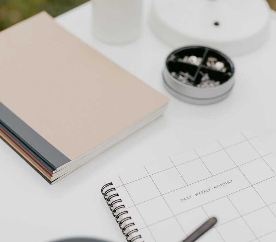 Organised desk with planner, notebook and coffee — external systems that support adult ADHD