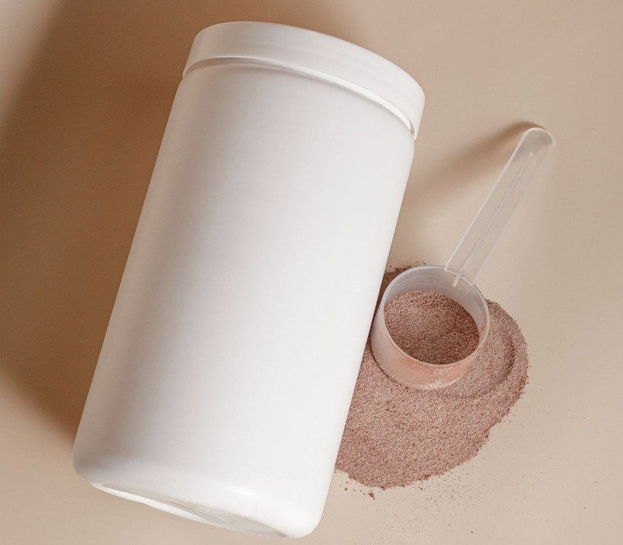 White tub of supplement powder with a measuring scoop, representing the hydrolyzed collagen peptide format discussed in the article