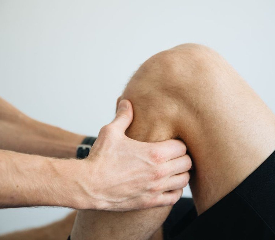 Physiotherapist massaging a patient's knee during a treatment session